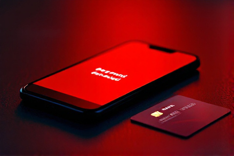 Smartphone showing payment declined notification with credit card on dark surface
