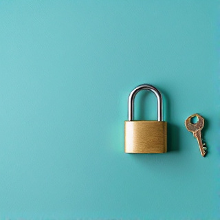 A brass key beside an open padlock on a teal surface, representing a successful account reinstatement