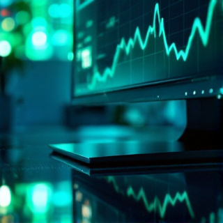 Monitor corner showing a rising green performance graph with teal glow reflecting on a dark desk