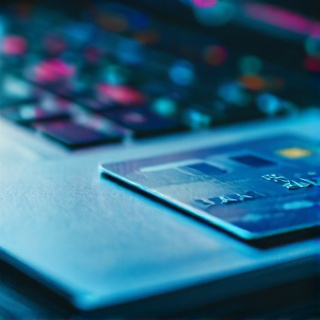 Bank card resting on documents next to a laptop for Google Ads payment verification